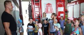 Strażak omawia i pokazuje dzieciom sprzęt pożarniczy