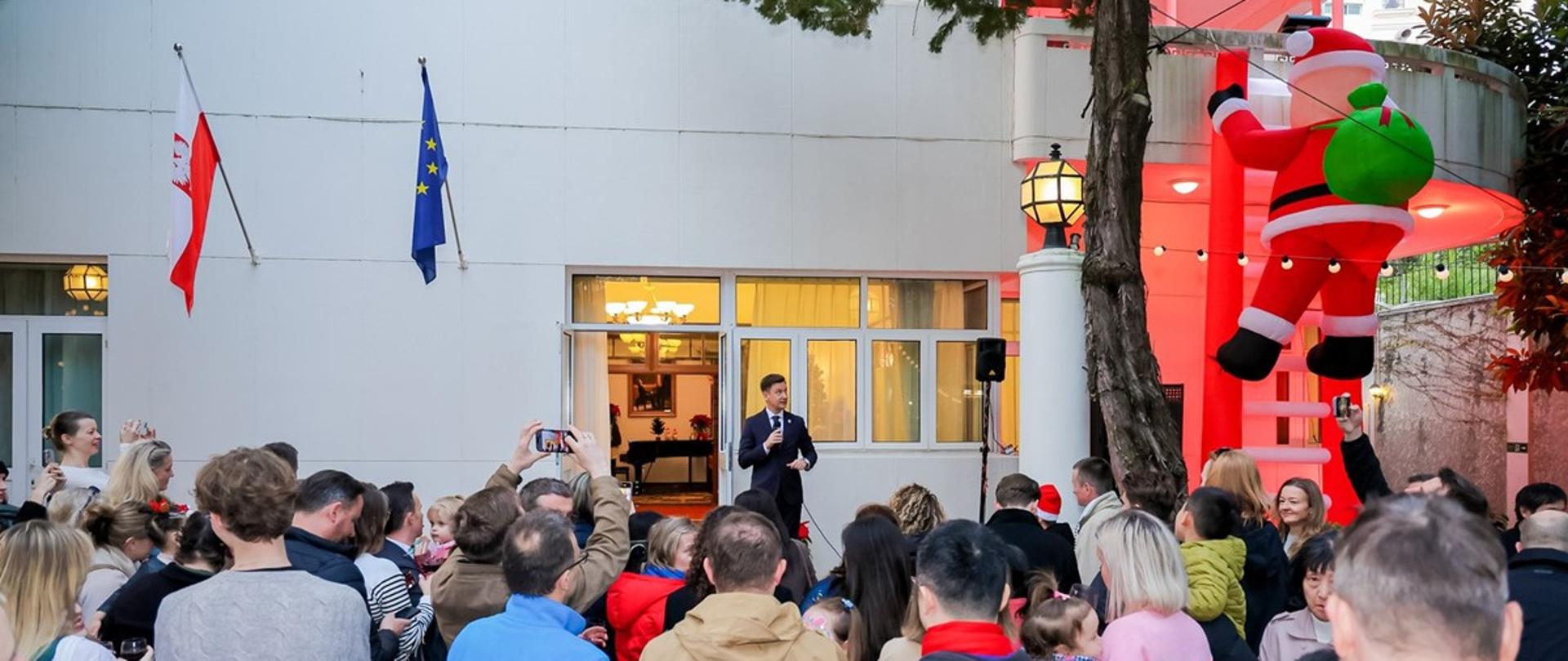 duża grupa ludzi w bożonarodzeniowej scenerii w ogrodzie