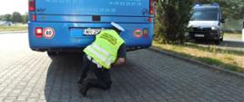 Inspektor transportu drogowego sprawdza czy z komory silnika autokaru nie wyciekają płyny eksploatacyjne. Ocenia też stan głównych elementów konstrukcyjnych podwozia pojazdu.