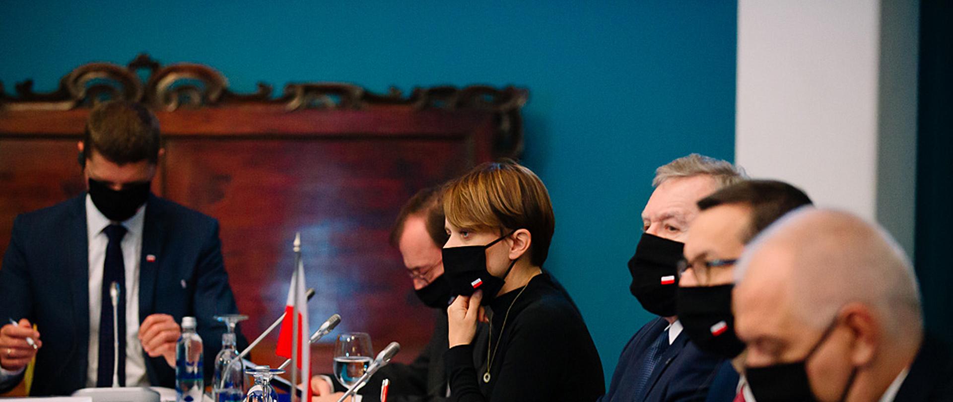 Jadwiga Emilewicz siedzi przy stole w jednej linii z premierem Morawieckim i przedstawicielami Rządu RP.