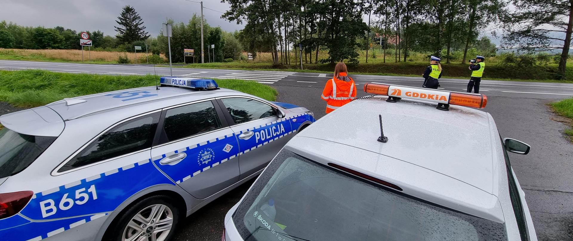 na zdjęciu widoczne pojazdy policji i GDDKiA. W tle widać dwie policjantki stojące przy drodze i pracownika GDDKiA 