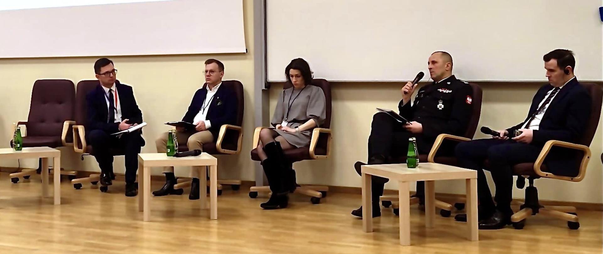 Scena w SG SP w Warszawie przedstawiająca panelistów forum BALTinnoSEC. Od lewej Adrian Bucałowski – zastępca dyrektora Biura Ochrony Ludności KG PSP oraz dr hab. Michał Głowacki z Katedry Systemów Medialnych Wydziału Dziennikarstwa, Informacji i Bibliologii Uniwersytetu Warszawskiego. Dr Maria Kordalewska – Business Relation Manager, m.in. st. bryg. Daniel Dryniak – Zastępca Podkarpackiego Komendanta Wojewódzkiego, Jakub Dzik dyrektor Wydziału Ratownictwa Medycznego i powiadamiania ratunkowego w Urzędzie Wojewódzkim