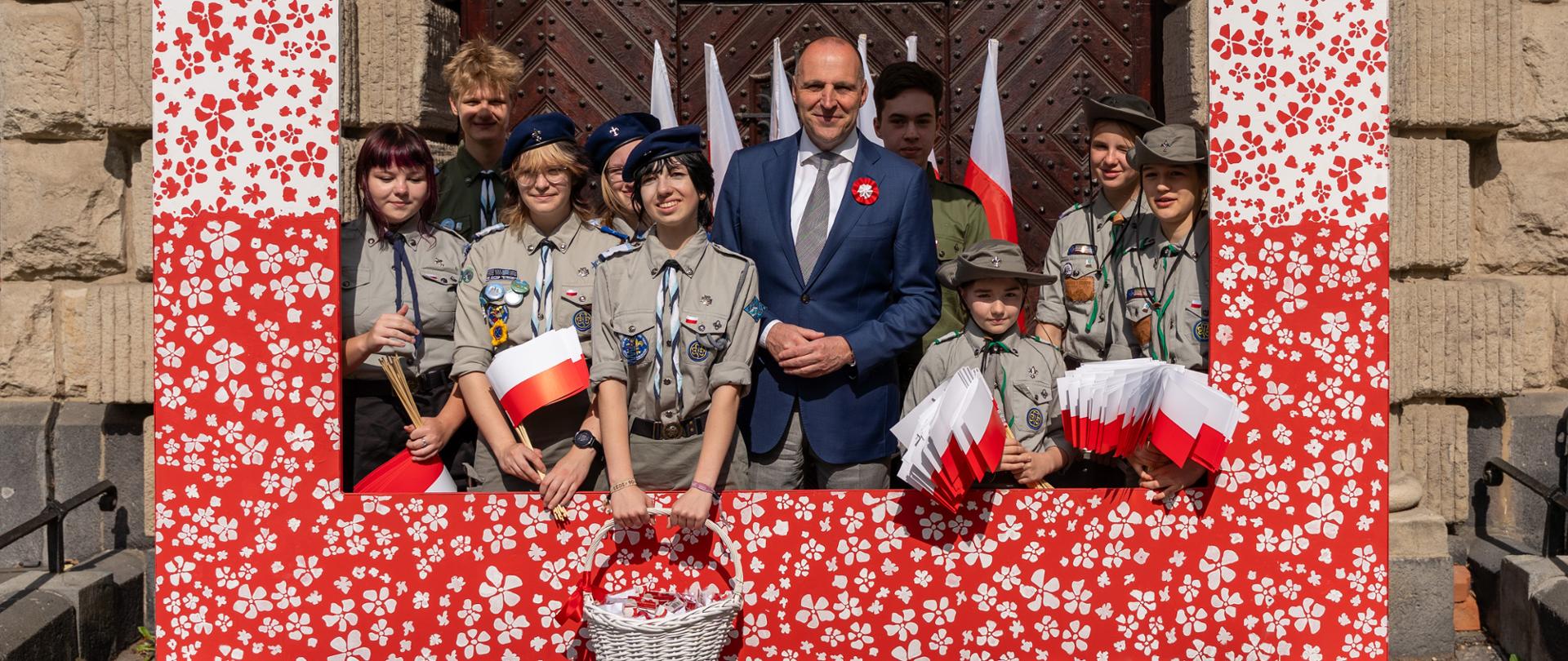 wojewoda z harcerzami w ramce fotograficznej pod urzędem