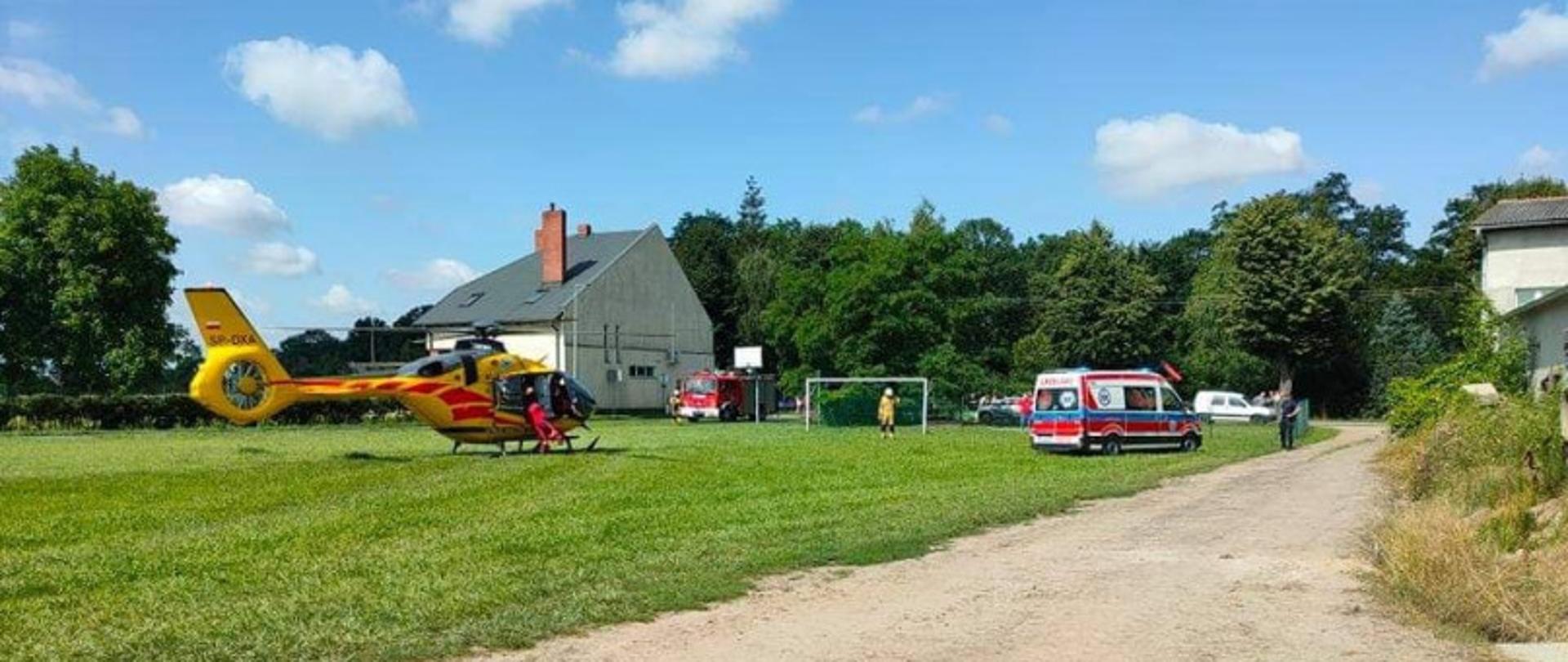 Zdjęcie przedstawia śmigłowiec LPR, samochód pożarniczy oraz karetkę pogotowia.