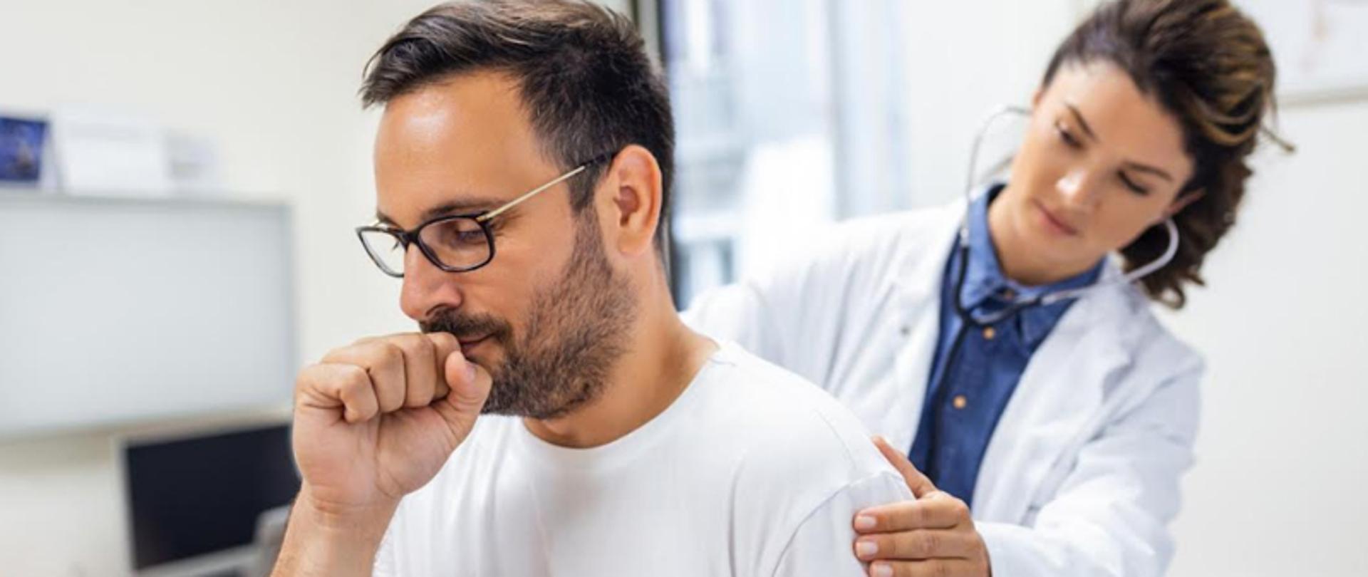 Kaszlący mężczyzna jest badany przez lekarkę