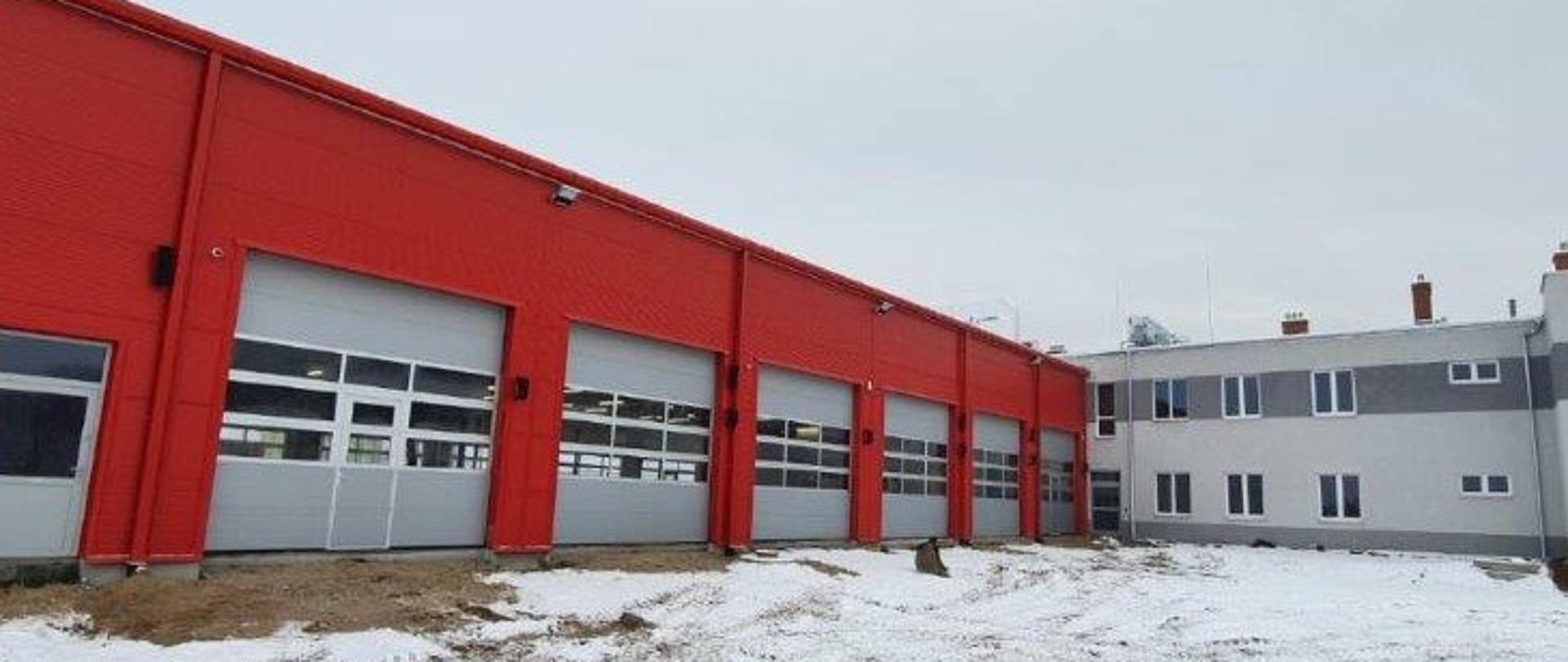 Zdjęcie przedstawia fragment nowobudowanego obiektu jednostki ratowniczo-gaśniczej w Szprotawie. Na zdjęciu fragment hali garażowej (po lewej) oraz obiektu administracyjnego (po prawej). 