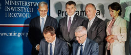 Podpisanie umowy o dofinansowanie obwodnicy Sanoka w ramach POIŚ.
Przy stole umowę podpisują (od lewej): Krzysztof Rodziewicz, Dyrektor Departamentu Przygotowania Projektów Centrum Unijnych Projektów Transportowych i Jacek Gryga, Zastępca Generalnego Dyrektora Dróg Krajowych i Autostrad
za nimi stoją (od lewej): Minister Inwestycji i Rozwoju Jerzy Kwieciński, Marszałek Sejmu RP Marek Kuchciński, Podsekretarz Stanu w Ministerstwie Infrastruktury Marek Chodkiewicz, Wicewojewoda Podkarpacki Lucyna Podhalicz.