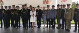 Na scenie stoją zaproszeni gości oraz uczestnicy Obchodów Dnia Strażaka w Bydgoszczy, tle baneru.