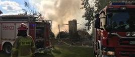 Zdjęci przedstawia pożar stodoły w miejscowości Leleszki, w tle samochody pożarnicze, strażak i dym nas spaloną stodołą.