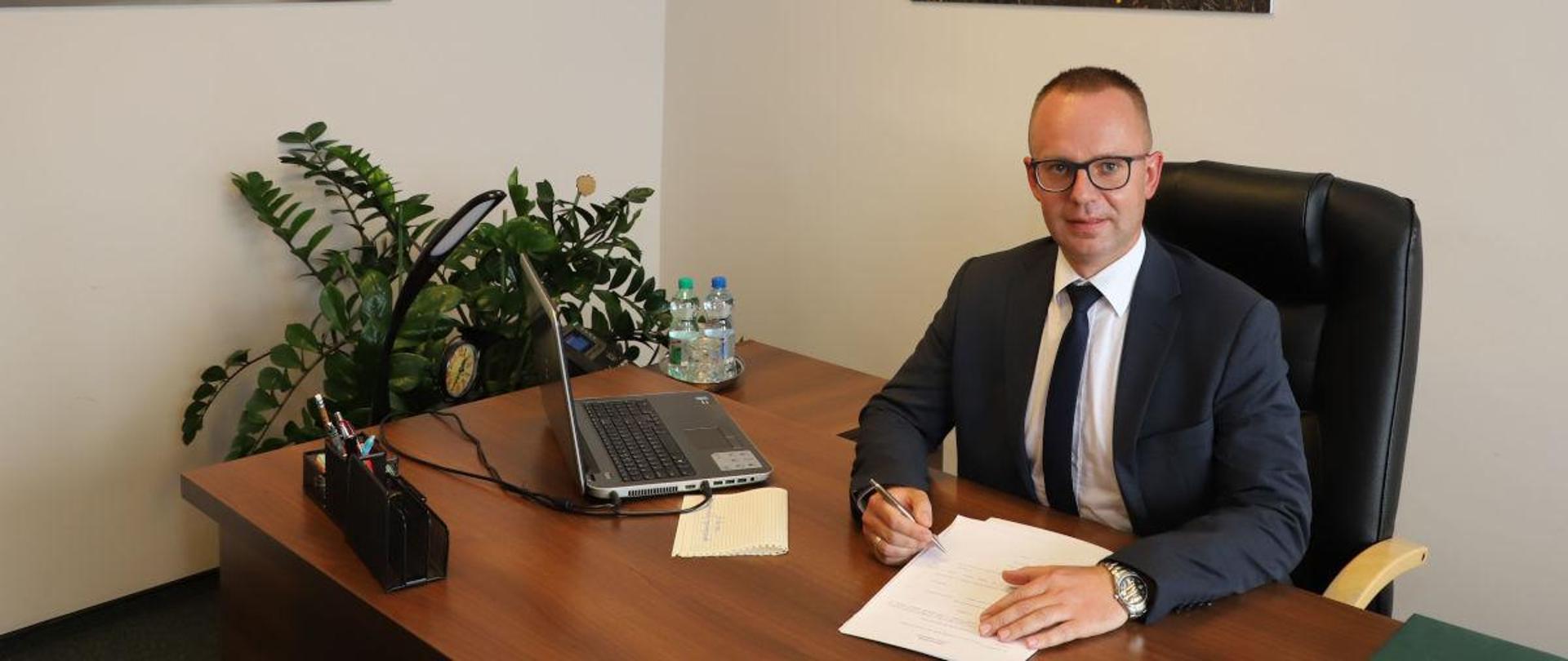 Pan Szymon Kosmalski, Regionalny Dyrektor Ochrony Środowiska w Bydgoszczy przy biurku w swoim gabinecie