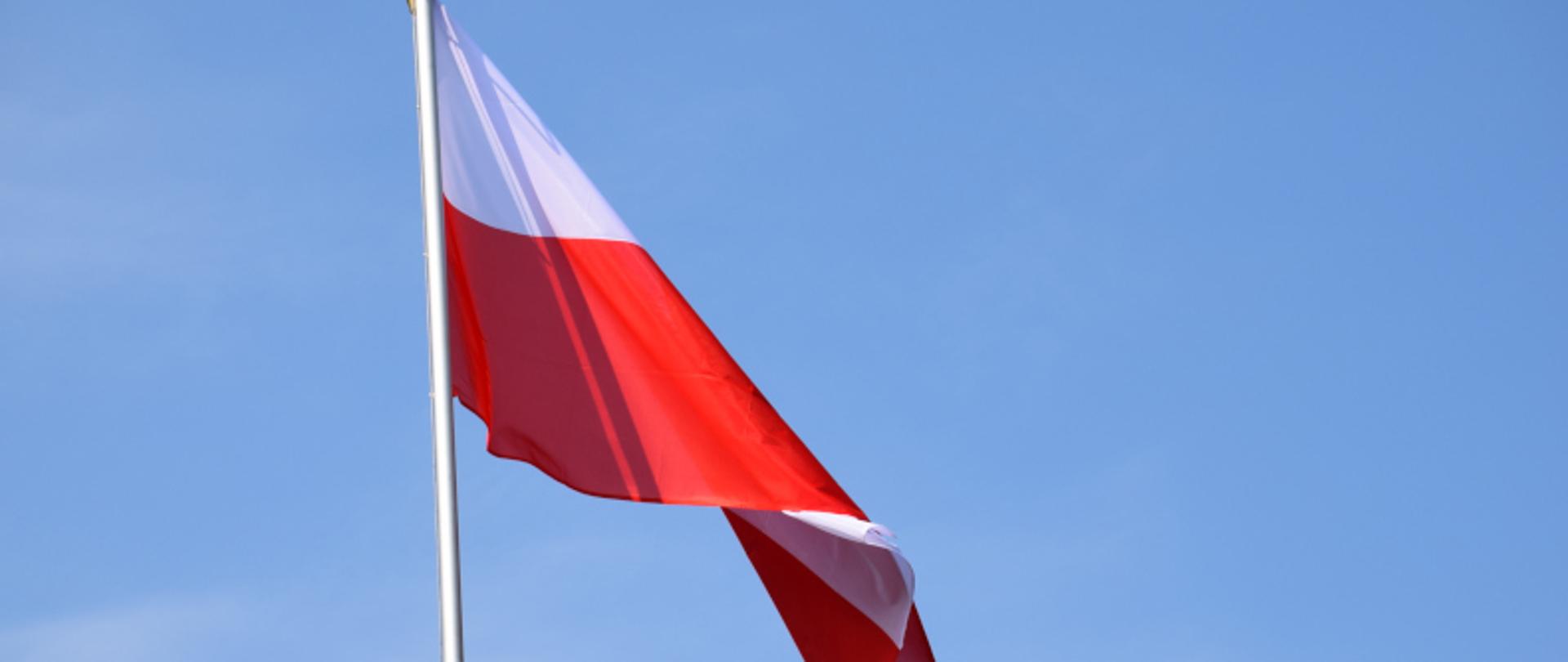 Flaga Rzeczpospolitej Polskiej powiewająca na wietrze