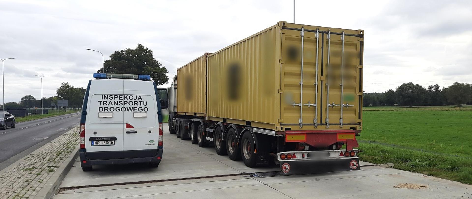Od lewej: tył oznakowanego furgonu mazowieckiej Inspekcji Transportu Drogowego. Obok stoi ciągnik siodłowy z podpiętą naczepą dzieloną z dwoma kontenerami. Wieloosiowy i przeładowany zespół pojazdów stoi tuż za rozłożonymi wagami inspekcyjnymi w punkcie kontrolnym.