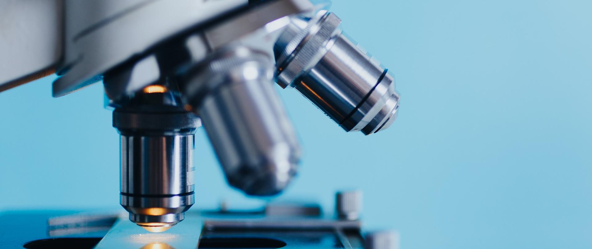 Po lewej stronie fragment mikroskopu, naświetlającego badaną próbkę