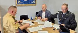Komendant, wójt gminy Gubin oraz prezes OSP podpisują porozumienie o współpracy – uroczyste spotkanie przy stole z dokumentami.