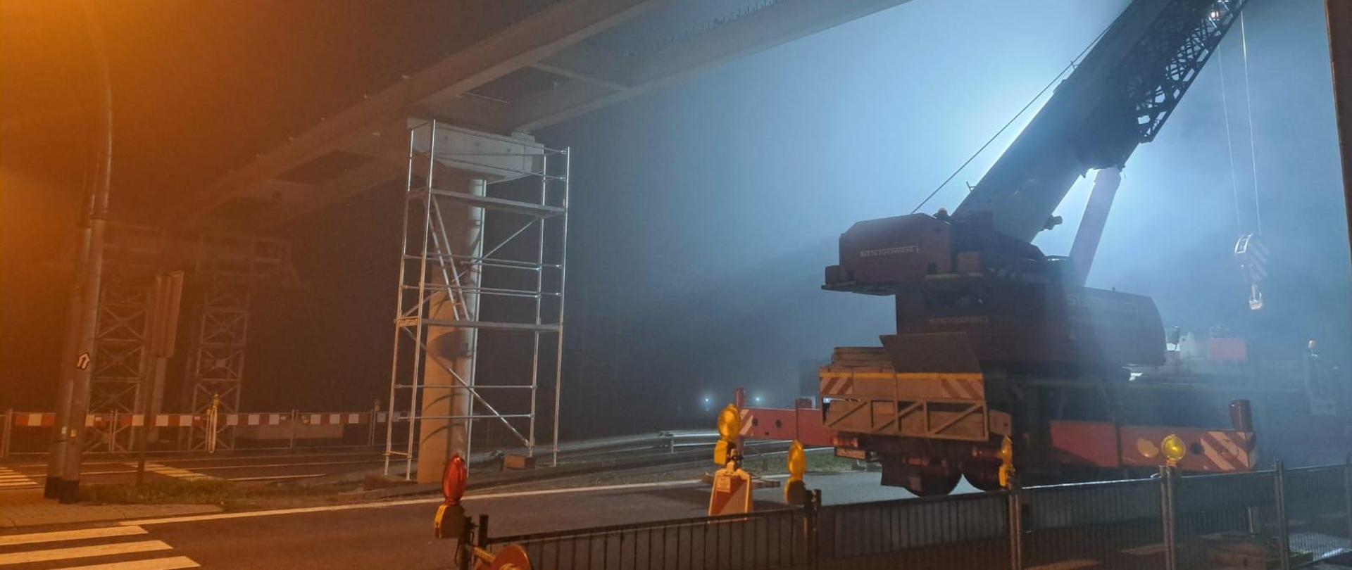 Nocne prace na kładce w Głogoczowie, ustawianie kładki na przęsłach, na pierwszym planie dźwig