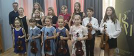 Zdjęcie przedstawiające wykonawców popisu klasy skrzypiec pani Kingi Biesiadeckiej, który odbył się 26 maja 2026 roku w małej auli, sali nr 3 w tzw. "starym" budynku szkoły.