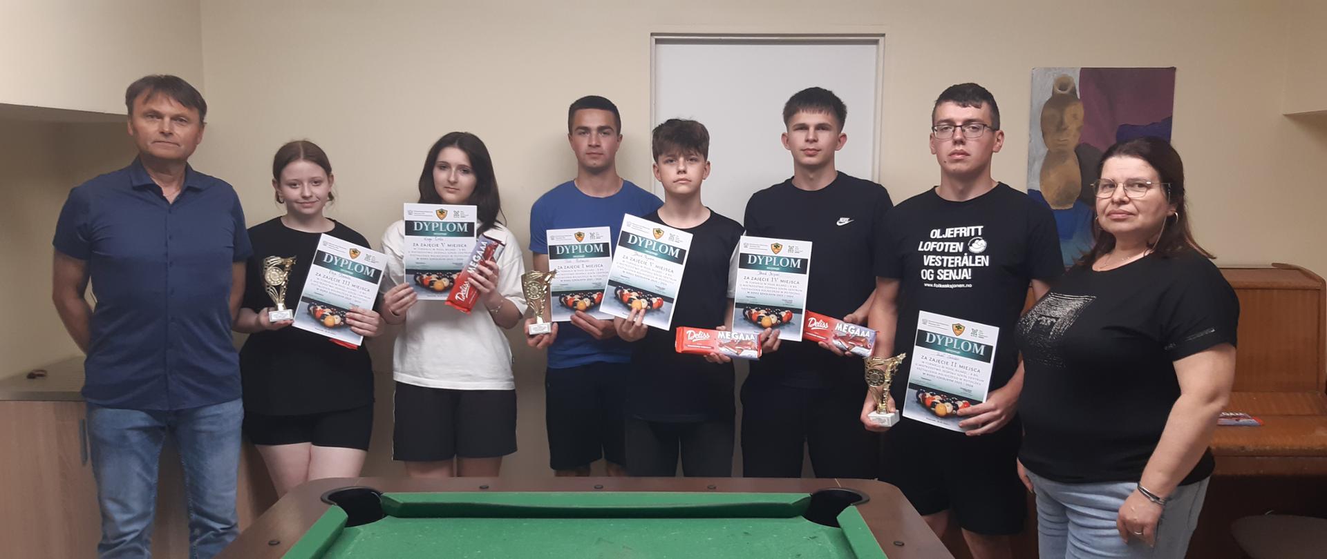 Zdjęcie 1 – pamiątkowe zdjęcie nagrodzonych uczestników turnieju finałowego, pierwsza z prawej kierownik internatu Agata Czajka, pierwszy z lewej nauczyciel wf Mariusz Karkusiewicz.