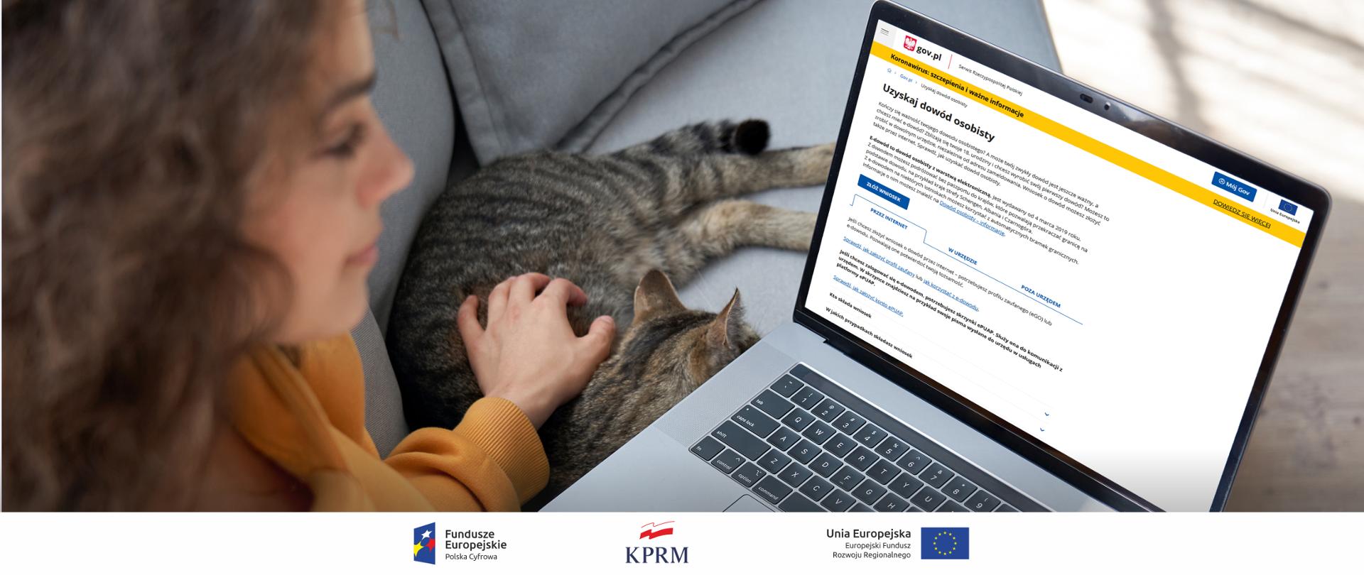 Młoda kobieta siedzi na kanapie, przed nią laptop z otwartą stroną GOV.pl i e-usługą "Uzyskaj dowód osobisty". Po lewej stronie laptopa - na kanapie leży kot. Kobieta głaszcze go lewą ręką.