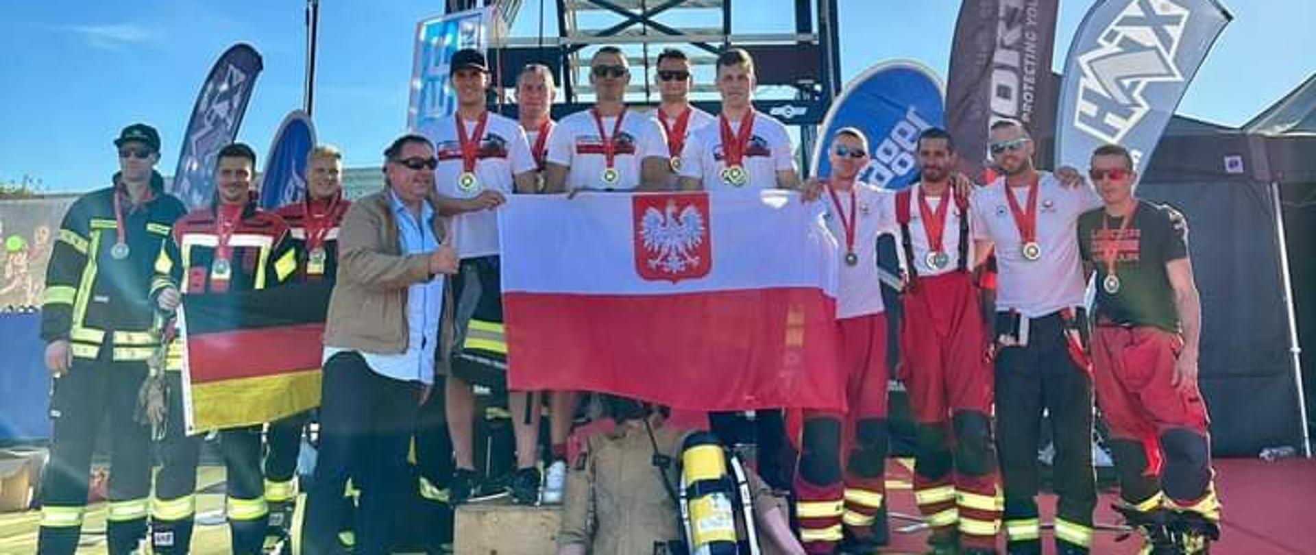 Strażacy - laureaci na podium, w tle wieża zawodów