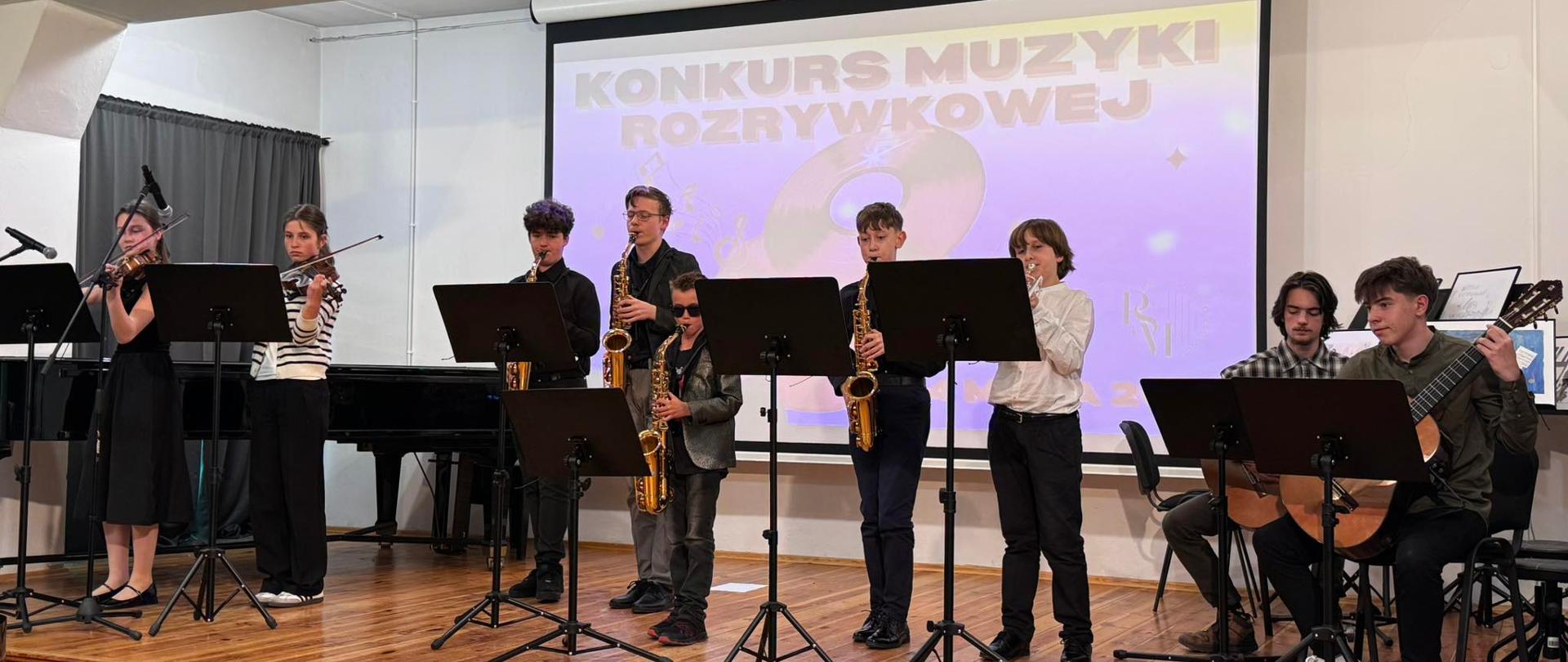 Zdjęcie przedstawiające wykonawców Konkursu Muzyki Rozrywkowej, który odbył się 14 maja 2026 roku w auli szkoły.