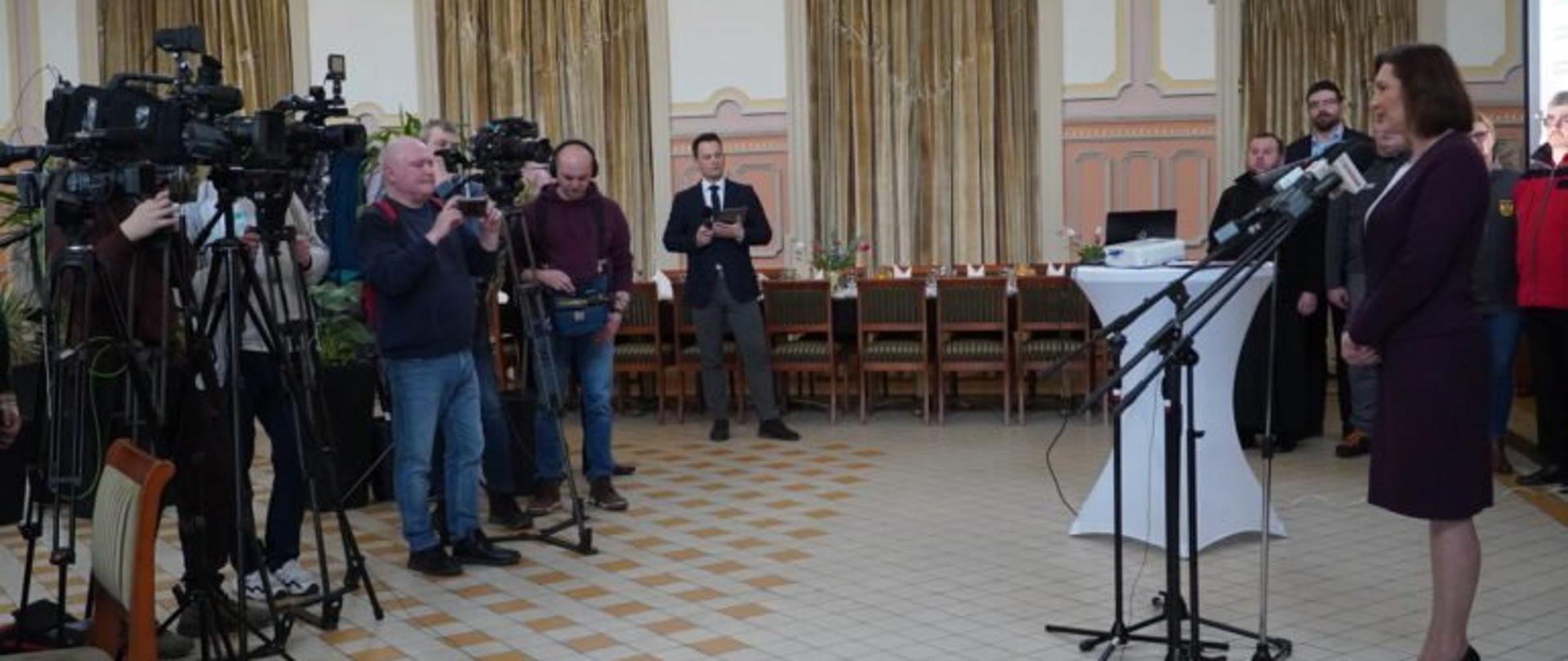 Wojewoda podkarpacki Ewa Leniart zabiera głos podczas konferencji prasowej podsumowującej rok pomocy dla uchodźców z Ukrainy. Przed wojewodą stoją 0przedstawiciele mediów 