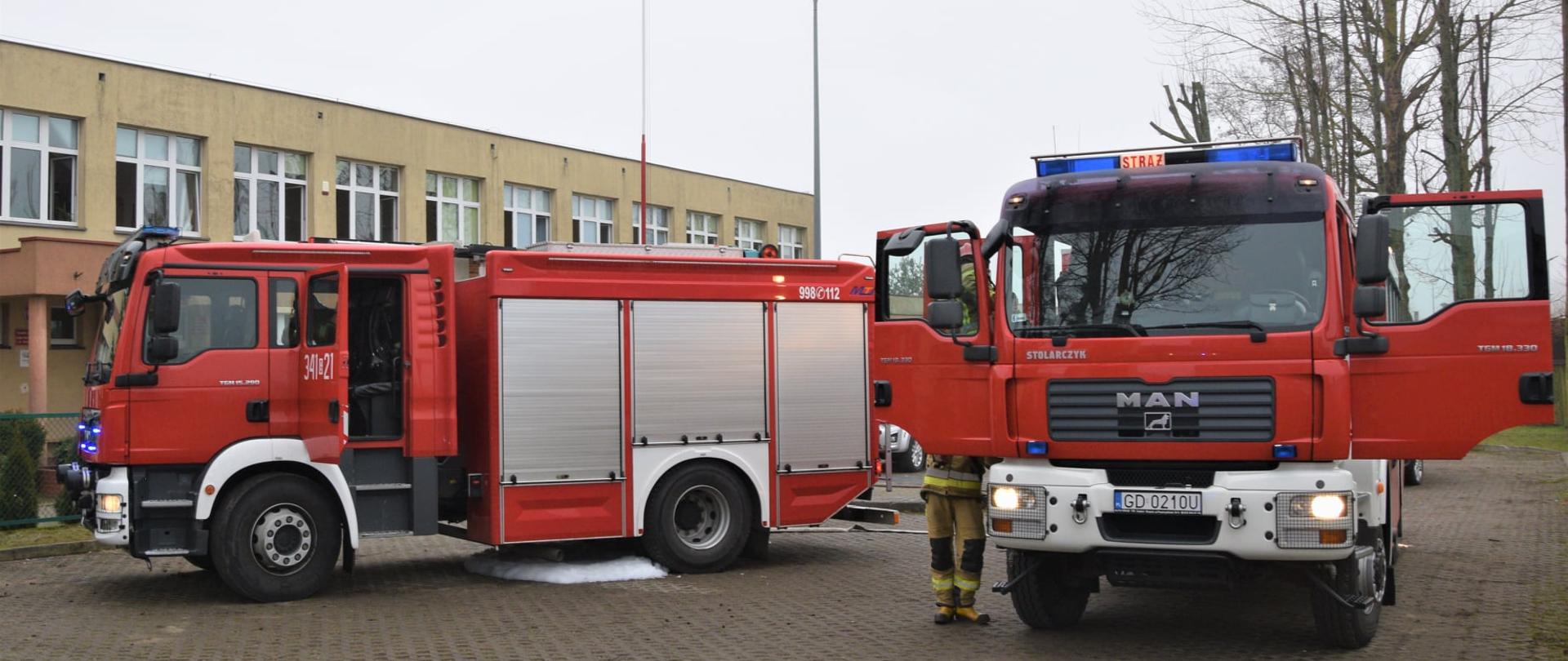 Zdjęcie przedstawia dwa samochody gaśnicze uczestniczące w akcji gaśniczej.