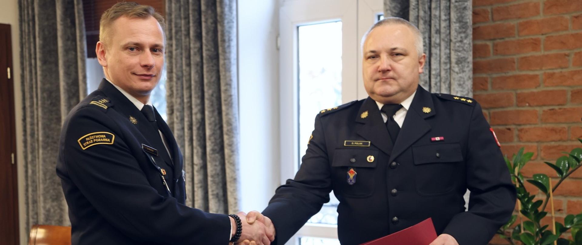 p.o. Komendant Centralnej Szkoły PSP w uścisku dłoni z oficerem CS PS, który przed chwila odebrał nagrodę MSWiA