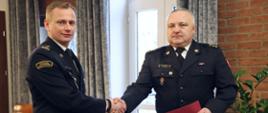 p.o. Komendant Centralnej Szkoły PSP w uścisku dłoni z oficerem CS PS, który przed chwila odebrał nagrodę MSWiA