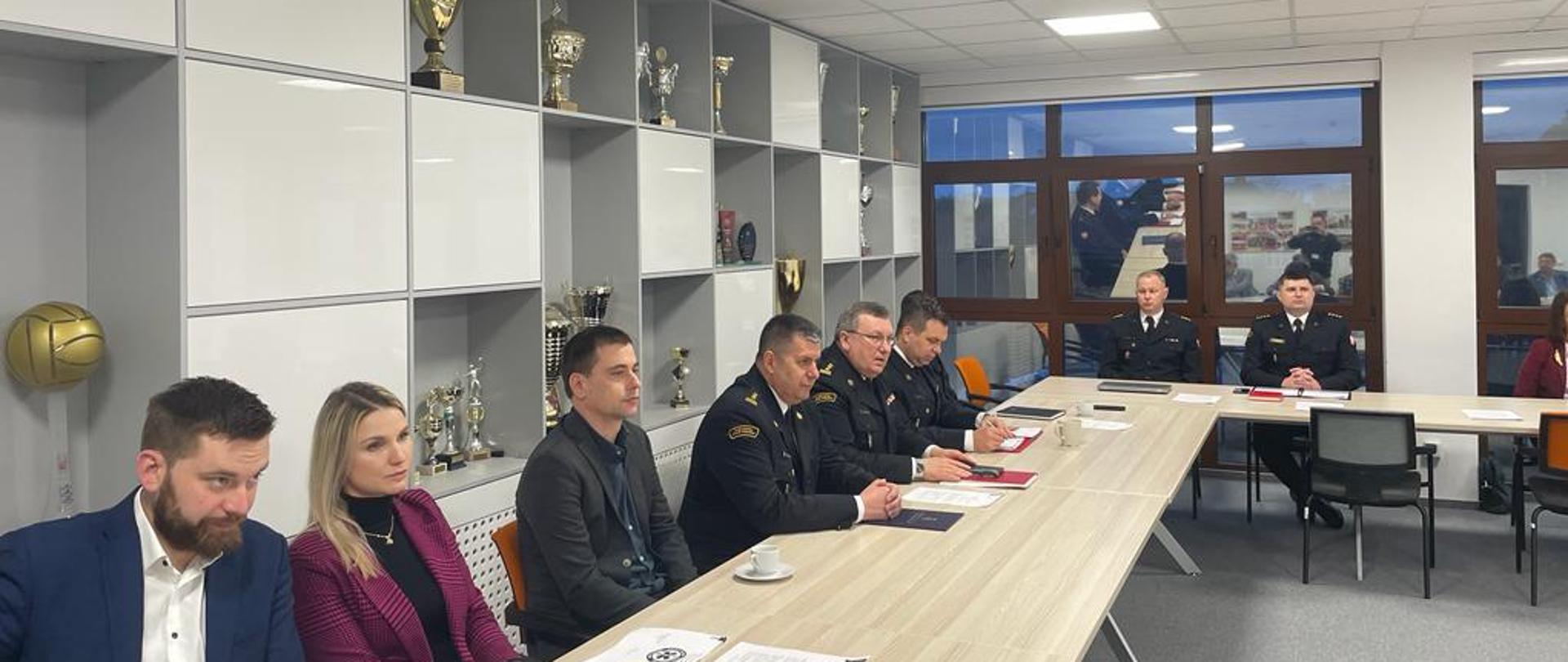 Osoby uczestniczące w spotkaniu w sali odpraw.