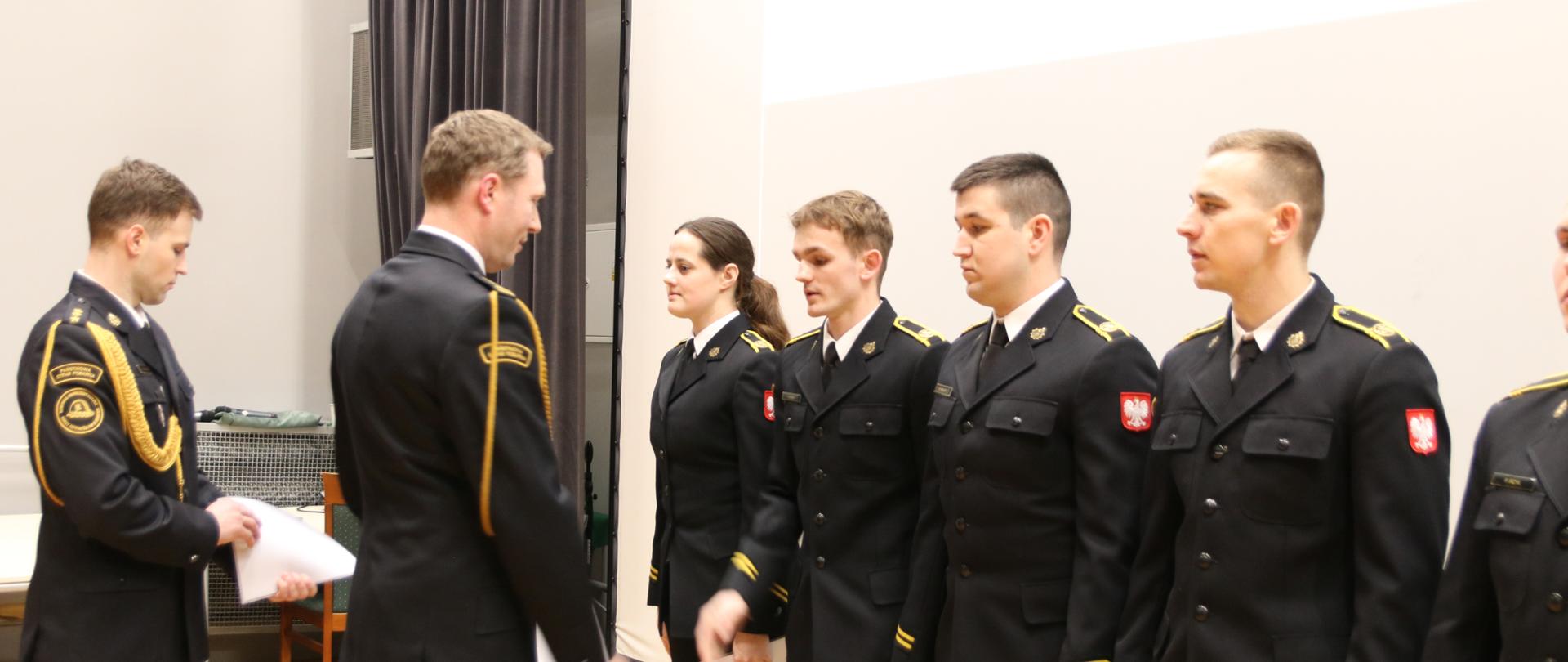 Pełniący obowiązki Komendant Szkoły Aspirantów PSP w Krakowie st.bryg. Piotr Gancarczyk w trakcie wręczania dokumentów o nadaniu wyższych stopni służbowych 