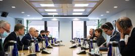 Boczne ujęcie stołu. Po jednej stronie siedzi wicepremier Jacek Sasin z członkami swojej delegacji, po drugiej stronie szefowa MFW ze współpracownikami