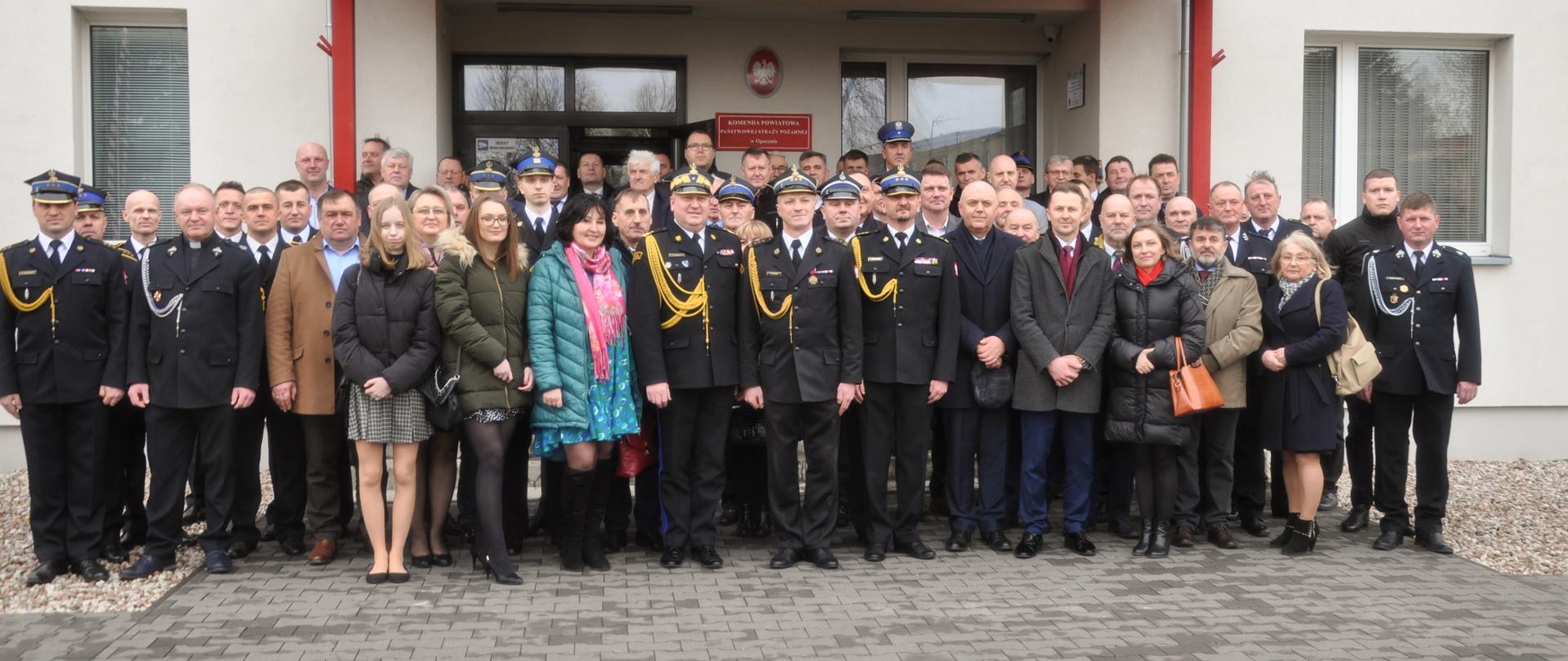 strażacy i uczestnicy pożegnania st. bryg. Andrzeja Śpiewaka pozują do zdjęcia na komendy powiatowej PSP w Opocznie