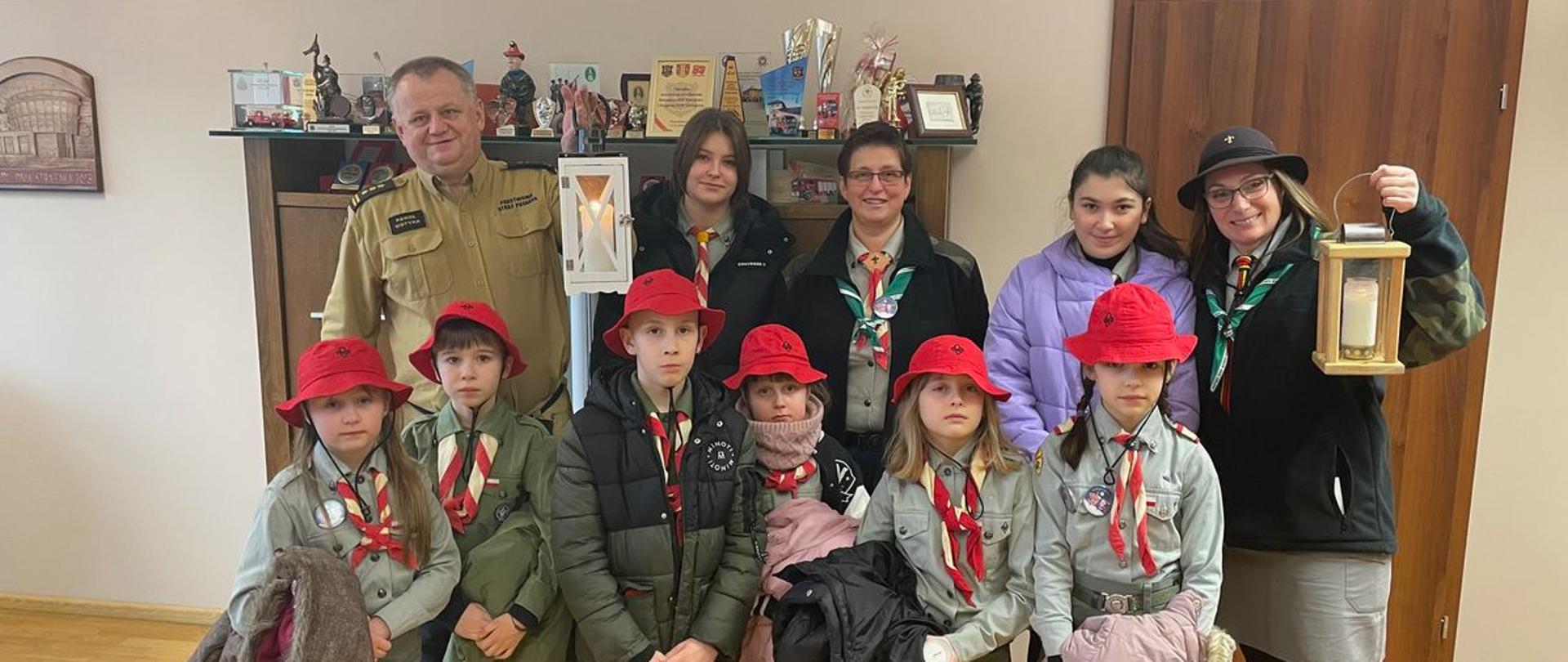 Komendant z harcerzami ze światełkami pokoju.