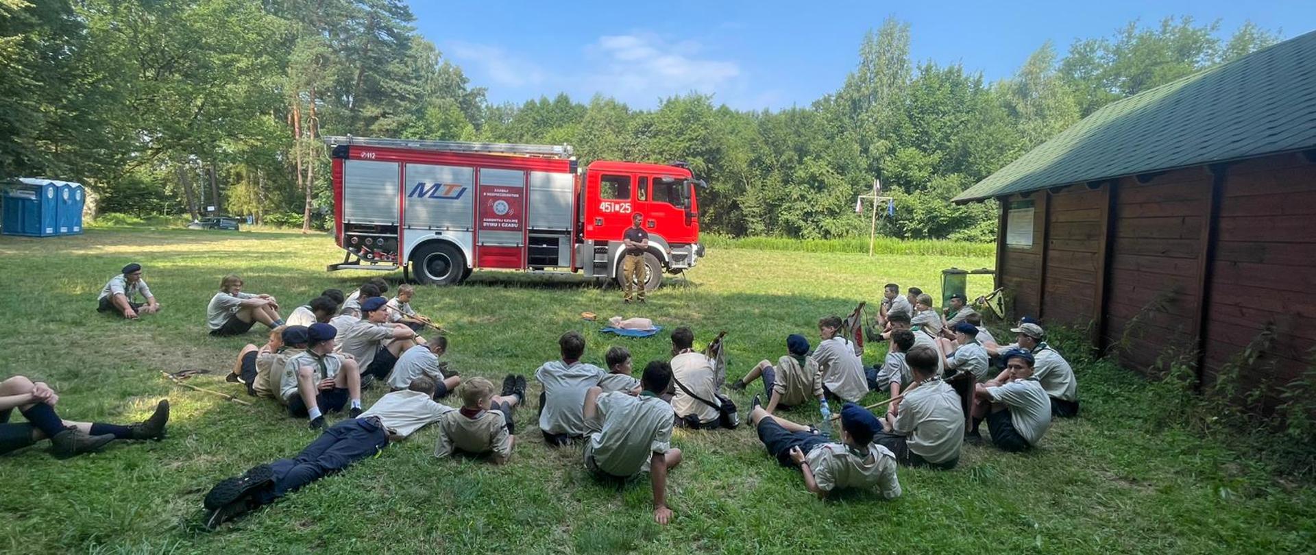 Szkolenie z zakresu udzielania pierwszej pomocy przedmedycznej dla uczestników obozu harcerskiego Skautów Europy 1 Hufca Jeleniogórsko-legnickiego. Na zdjęciu widoczna grupa młodzieży podczas prelekcji.