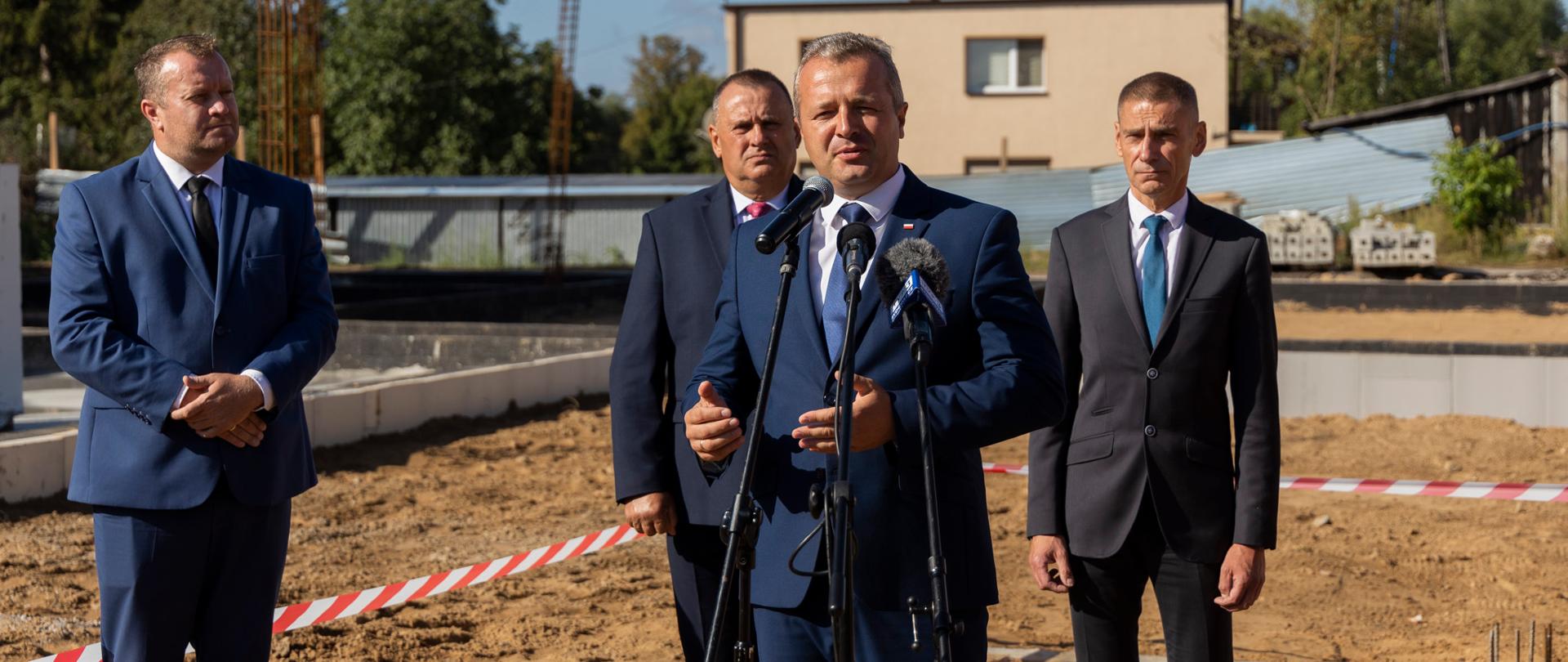 
Grupa ludzi w garniturach stojąca na placu budowy
