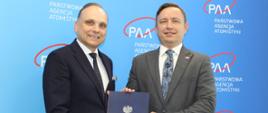 Prezes PAA Andrzej Głowacki i Paweł Pichniarczyk, dyrektor Łukasiewicz – Instytutu Ceramiki i Materiałów Budowlanych trzymają teczkę z decyzją o przyznaniu autoryzacji PAA