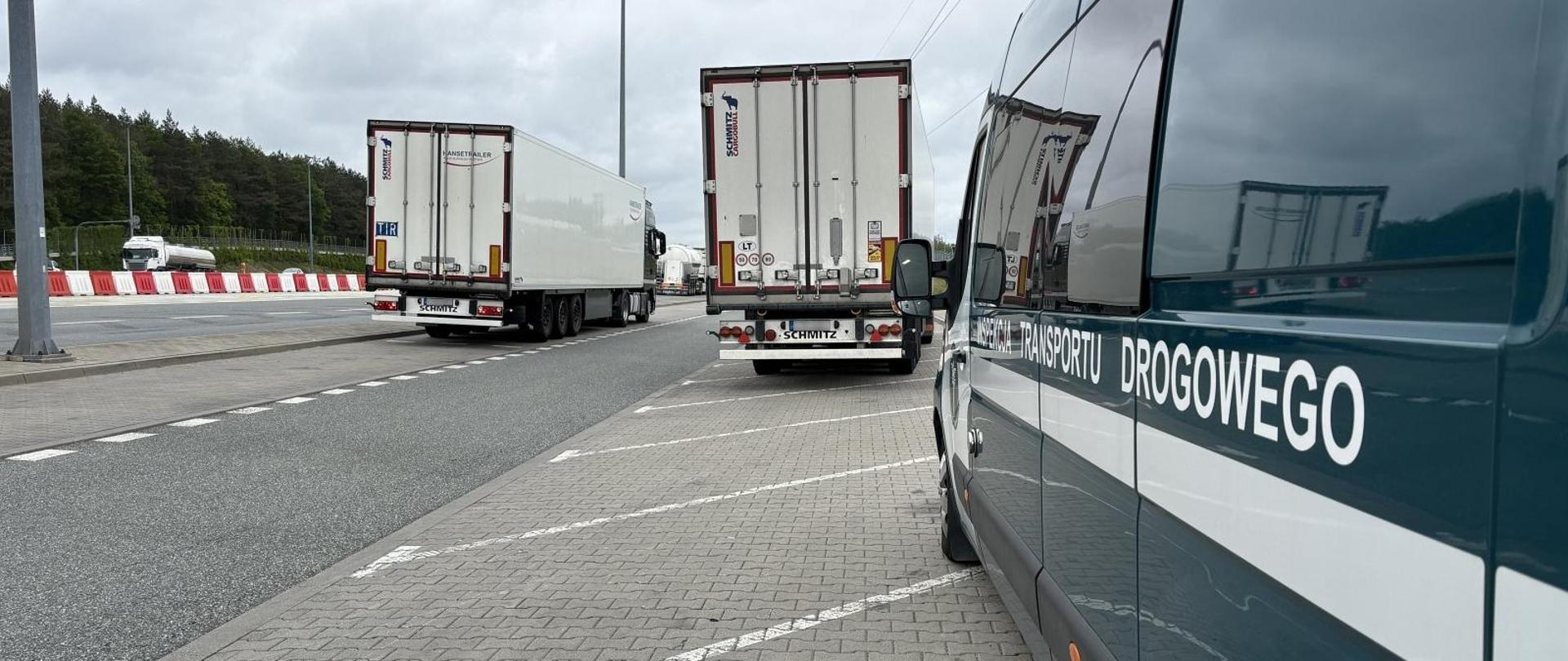 Na punkcie kontrolnym stojące 2 pojazdy ciężarowe oraz widoczny bok busa inspekcyjnego z napisem Inspekcja Transportu Drogowego 