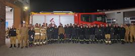 Zdjęcie przedstawia strażaków na tle samochodu, którzy ukończyli szkolenie dowódców OSP.