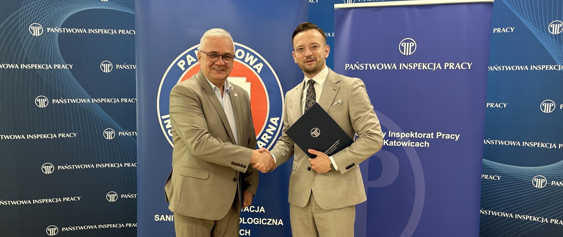 Podpisanie porozumienia przez dr n. med. Grzegorza Hudzika - Śląskiego Państwowego Wojewódzkiego Inspektora Sanitarnego i Piotra Kalbrona - Okręgowego Inspektora Pracy w Katowicach