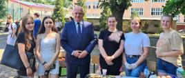 Wojewoda pozuje do wspólnego zdjęcia z uczennicami w czasie festynu w I Zespole Szkół we Wschowie 