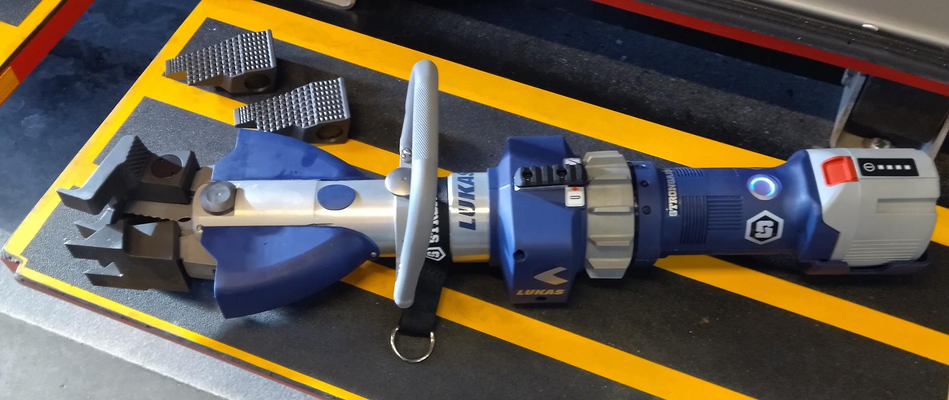 Nożyce StrongArm leżą na podeście samochodu ratowniczo-gaśniczego