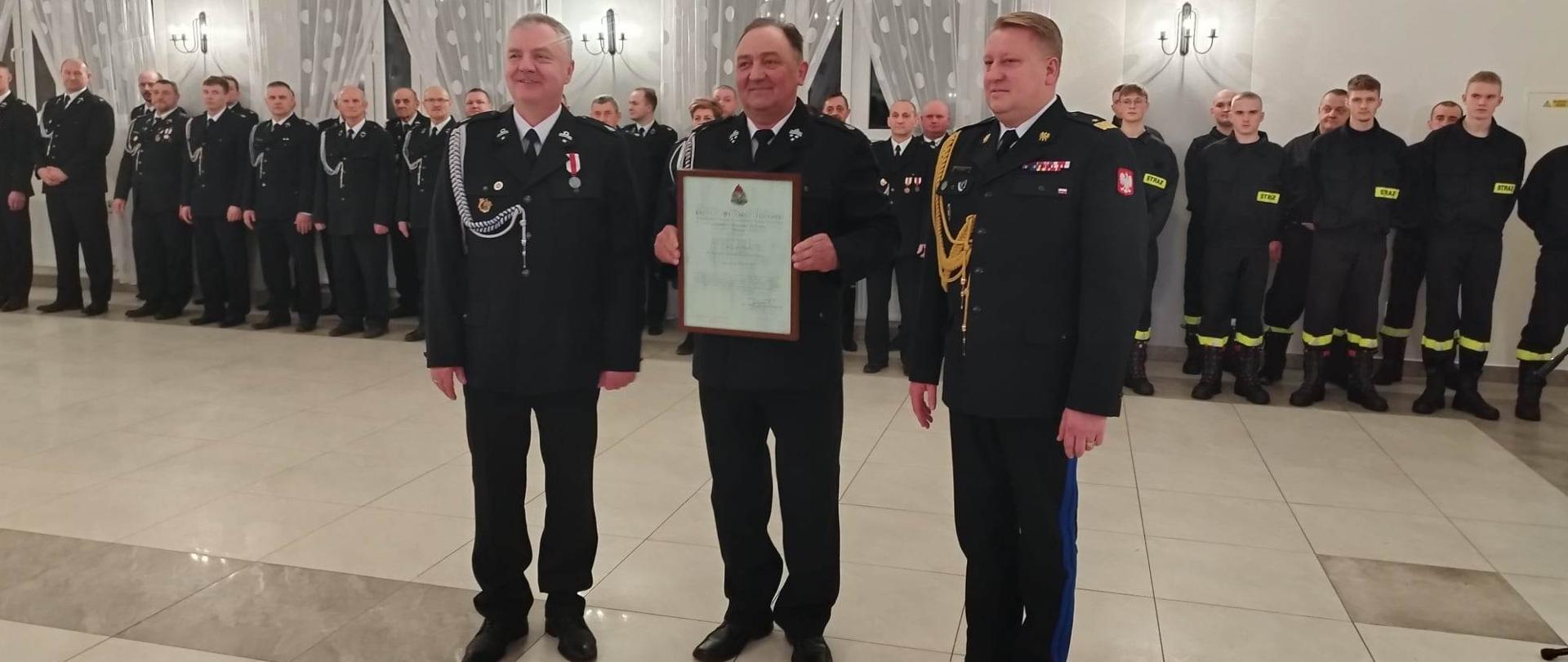 komendanci i prezes osp pre\entują decyzję