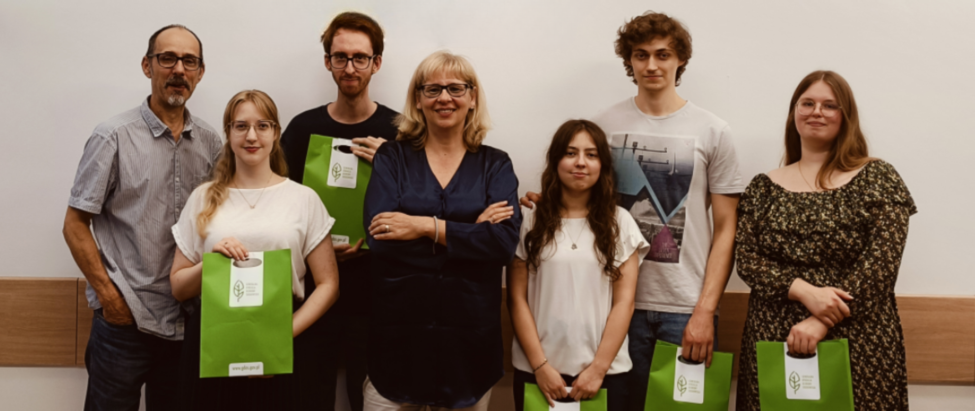 Zdjęcie przedstawia trzech mężczyzn i cztery kobiety. Wszyscy pozują do zdjęcia i są uśmiechnięci. W środkowej części zdjęcia widać kobietę w okularach i jasnych włosach sięgających ramion, jest to Anna Ronikier-Dolańska - Zastępca Generalnego Dyrektora Ochrony Środowiska.