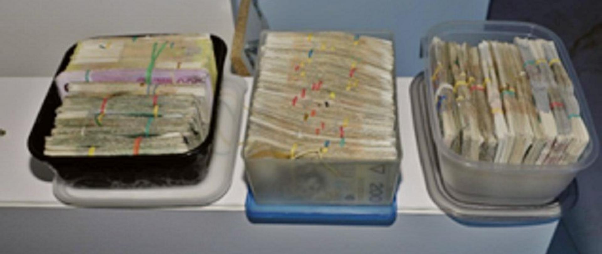 setki tysięcy banknotów poukładane w plastikowych pudełkach