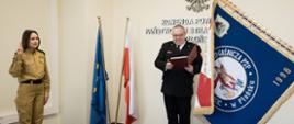 Strażak Klaudia Wrońska w mundurze koloru piaskowego ślubuje na Sztandar Komendy Powiatowej PSP w Płońsku.