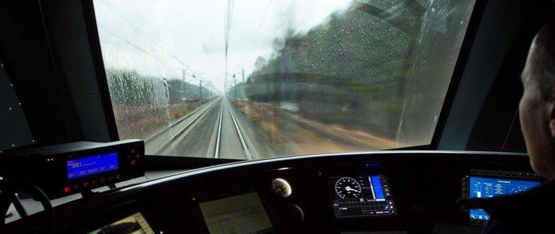 Na zdjęciu widać maszynistę w swojej kabinie, który prowadzi pociąg