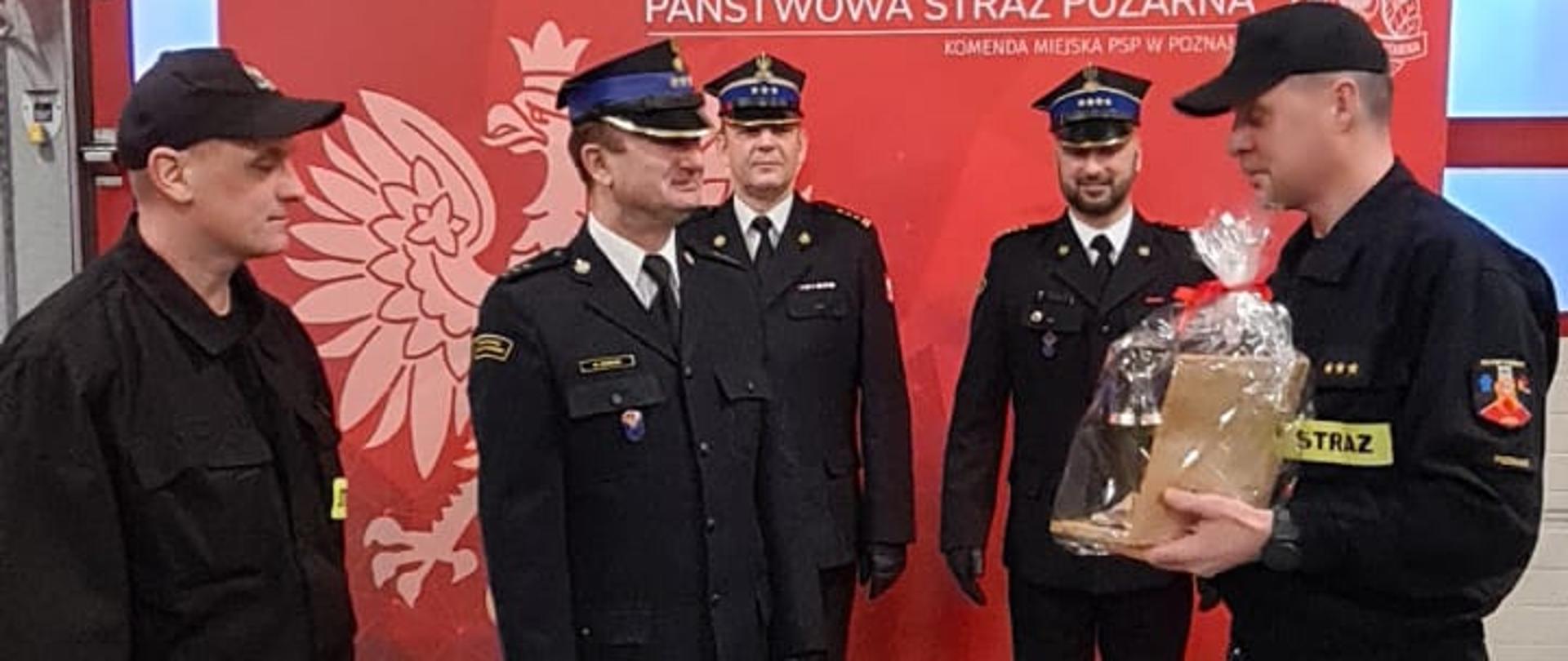 funkcjonariusze JRG 8 wręczają upominek kpt. Markowi Koteckiemu