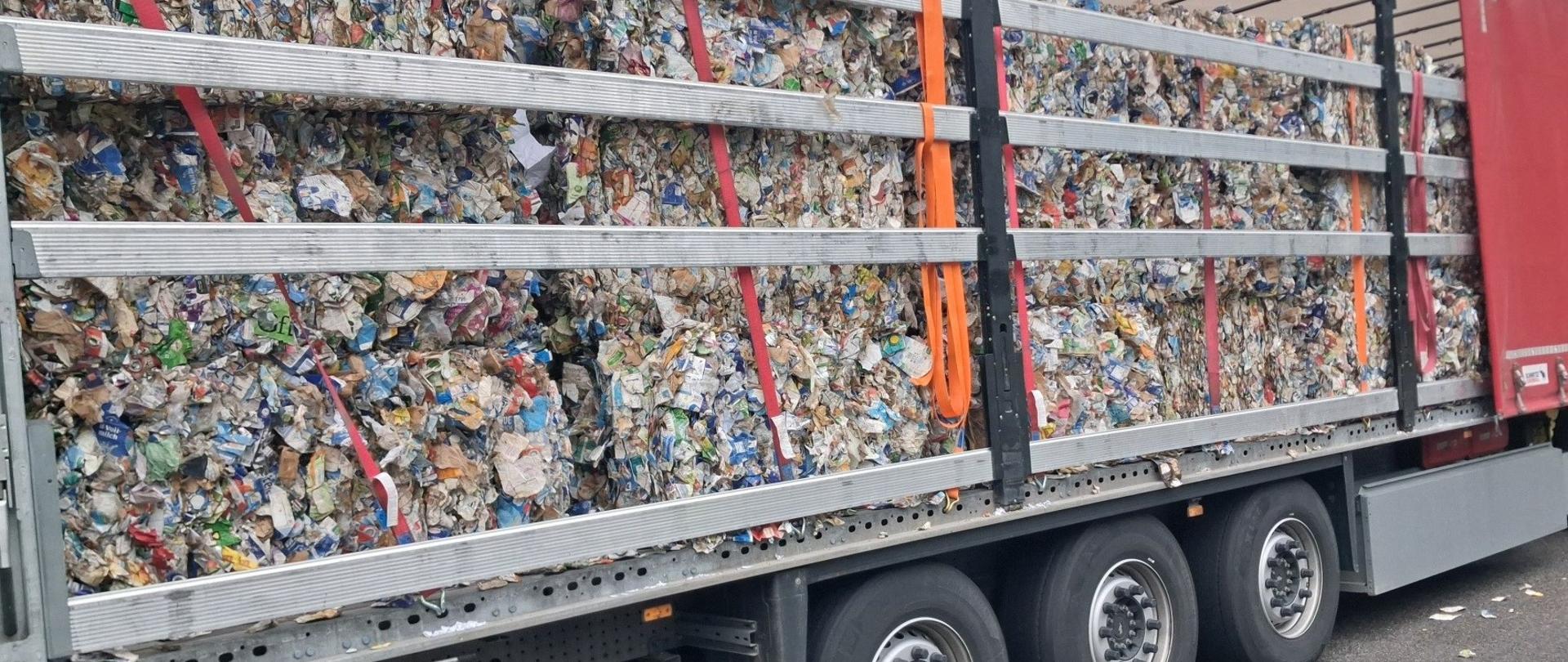 Naczepa samochodu ciężarowego z odpadami.