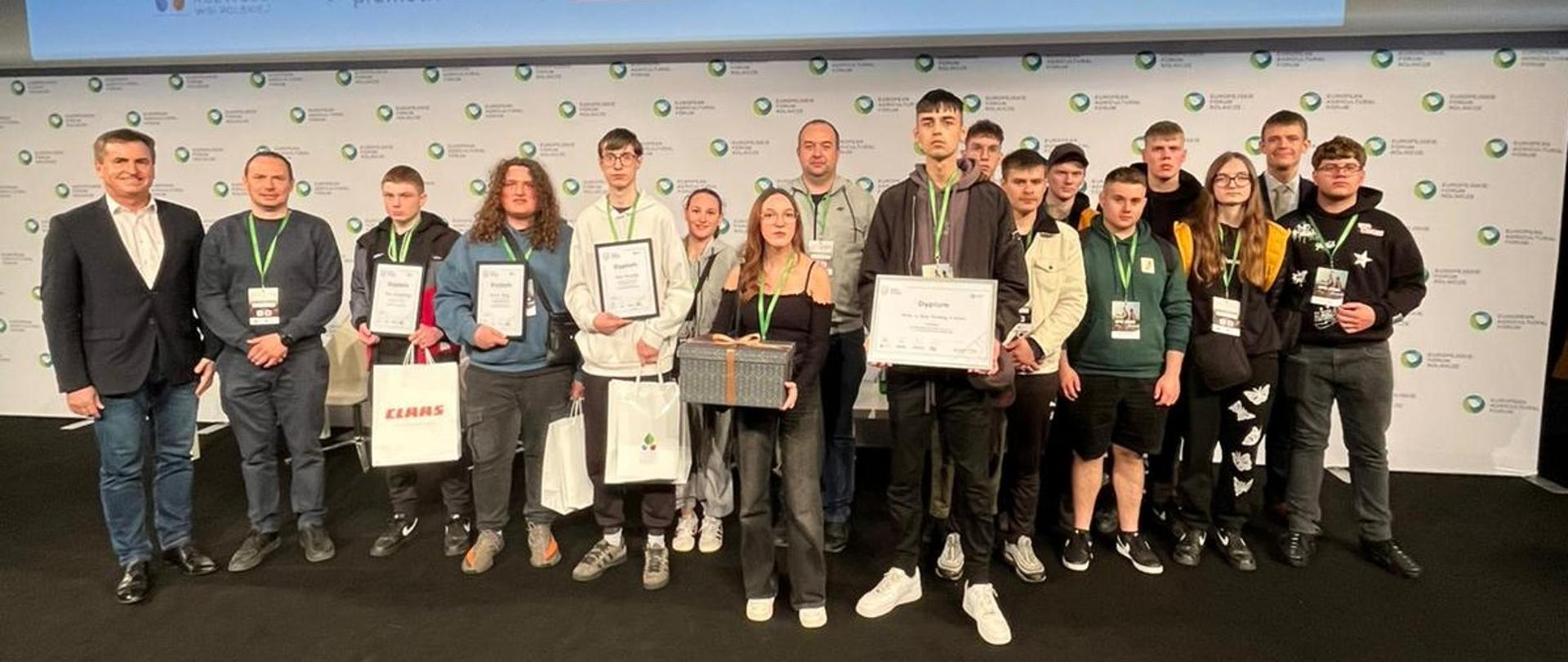 Grupa uczestników z dyplomami pozuje na scenie pod ekranem z napisem EFR 2026.