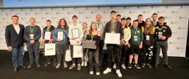 Grupa uczestników z dyplomami pozuje na scenie pod ekranem z napisem EFR 2026.